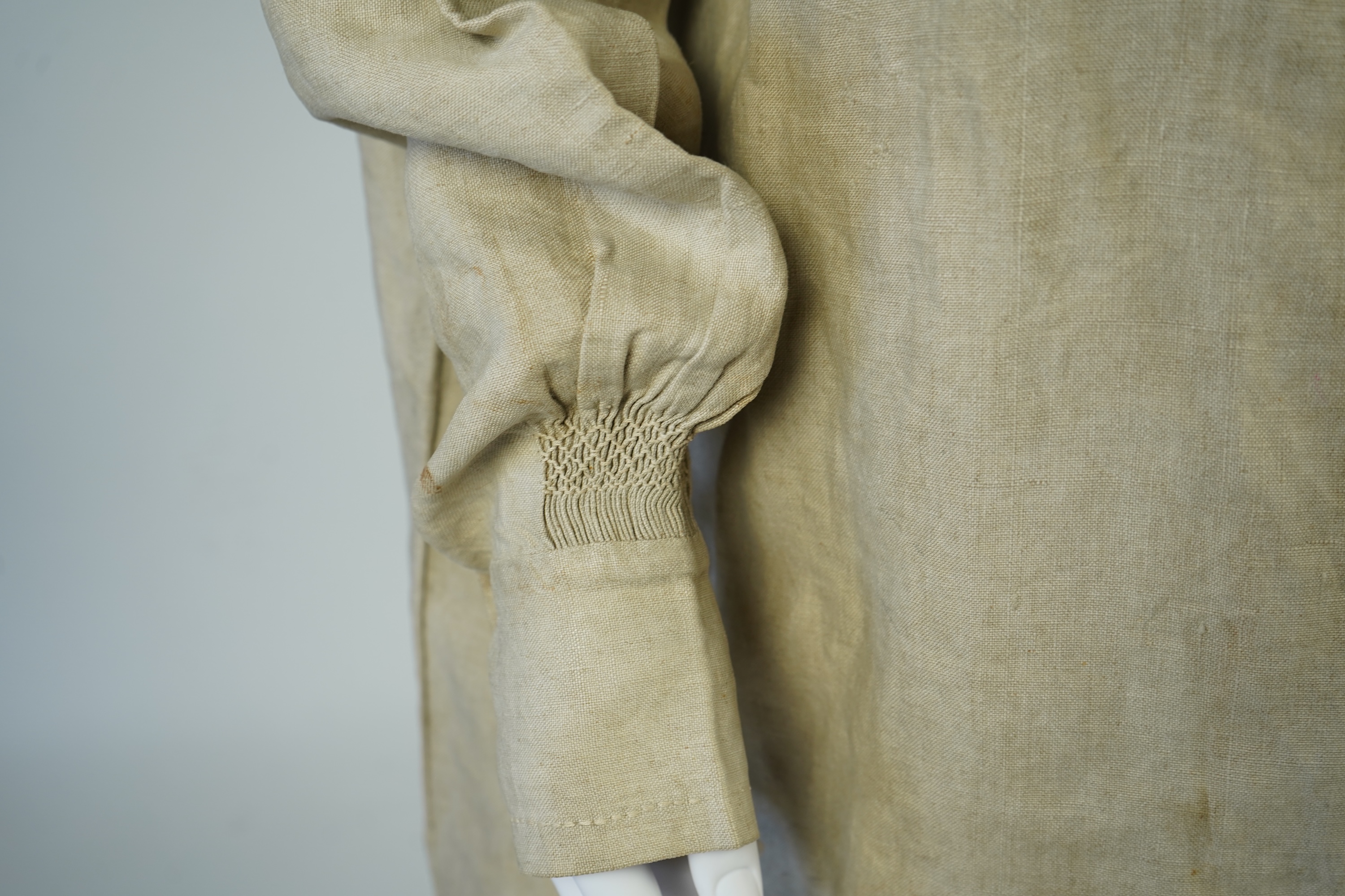 A 19th century heavy linen Shepherd’s smock, with small smocked shoulders and front and back neck panels under collar., 97cm long. Condition - patched and small darn near top and minor wear, usual for age and use.